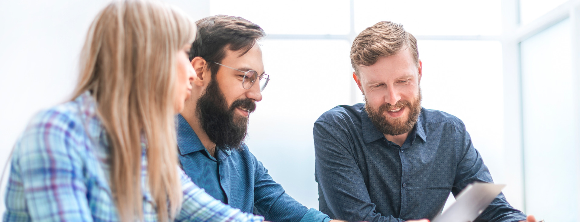 drei Kollegen gucken zusammen auf einen Tablet drei Kollegen gucken zusammen auf einen Tablet